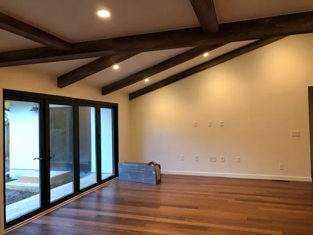 Restored living space with exposed wood-beam ceiling